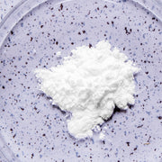 White powder (dairy-digesting enzymes) on a purple speckled background