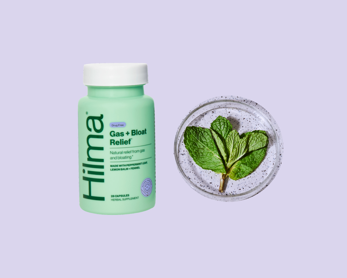 Gas + Bloat Relief bottle next to peppermint leaf in a petri dish on a purple background