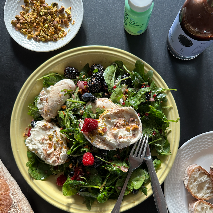 Plate of arugula with burrata and berries