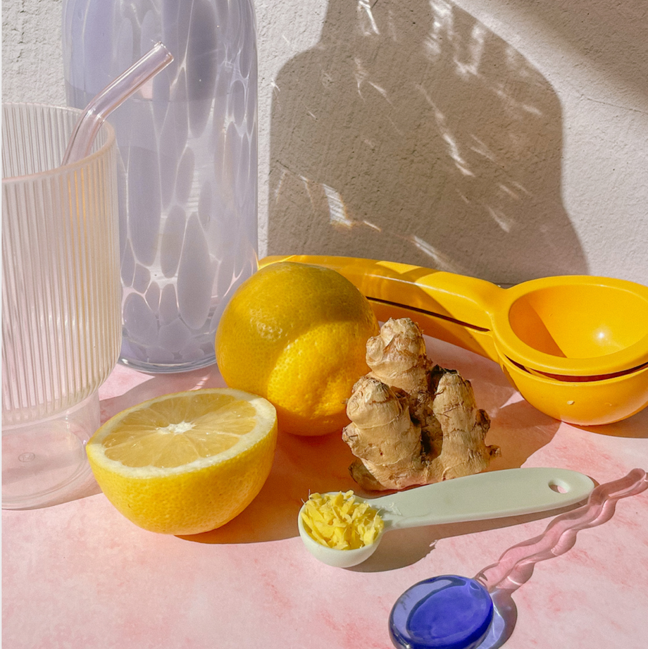 Lemon and ginger on tabletop with glass and lemon-squeezer