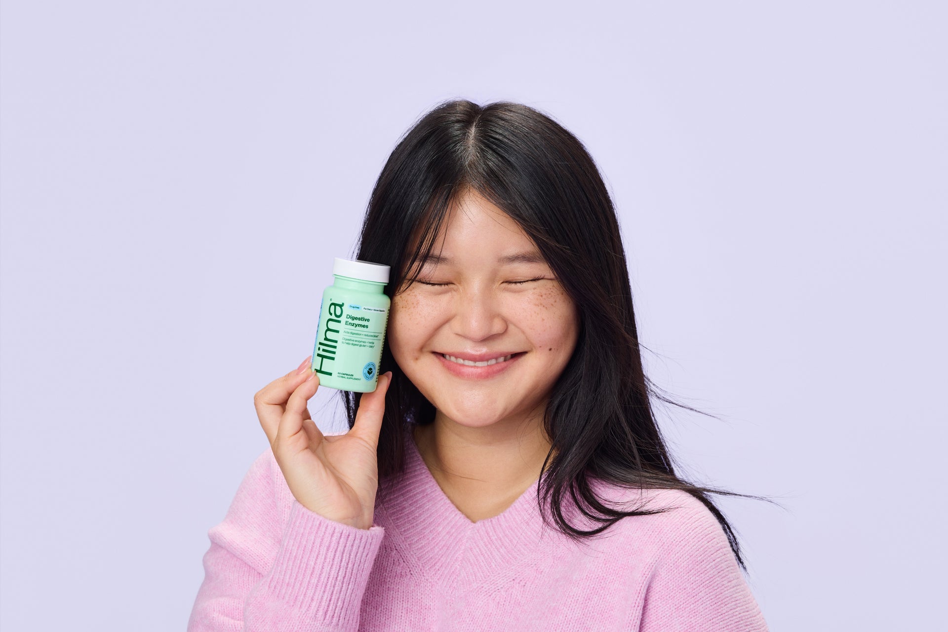 Smiling woman holding digestive enzymes
