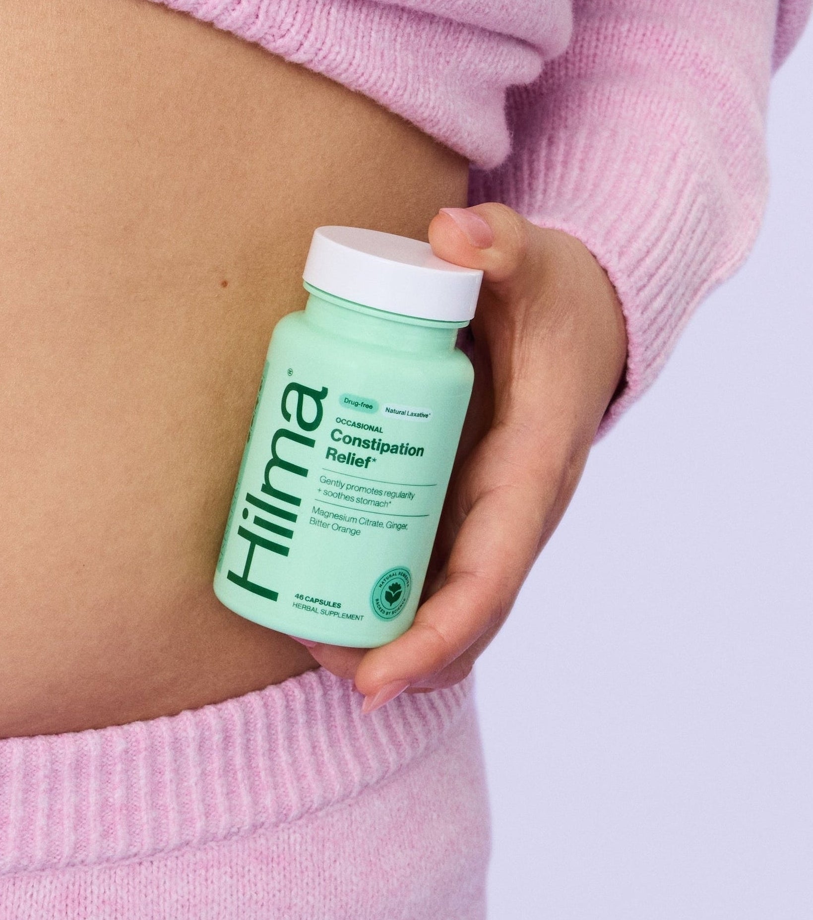 Woman holding constipation relief in front of her stomach