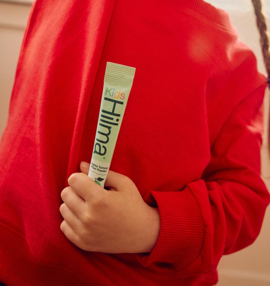 Child holding happy tummy fiber powder in hand