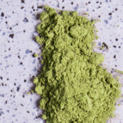Green powder (l-theanine)  on a purple speckled background