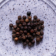 Black pepper kernels on a purple speckled background