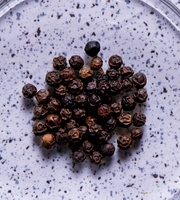 Black pepper kernels on a purple speckled background