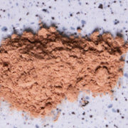 Brown powder (reishi mushroom)  on a purple speckled background